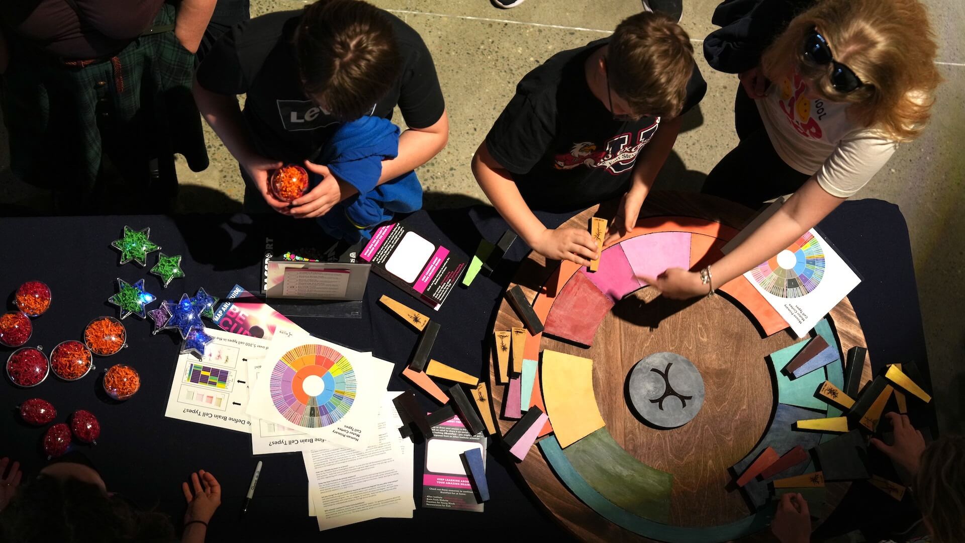 Group of people working on color theory and design projects at a collaborative workshop table.