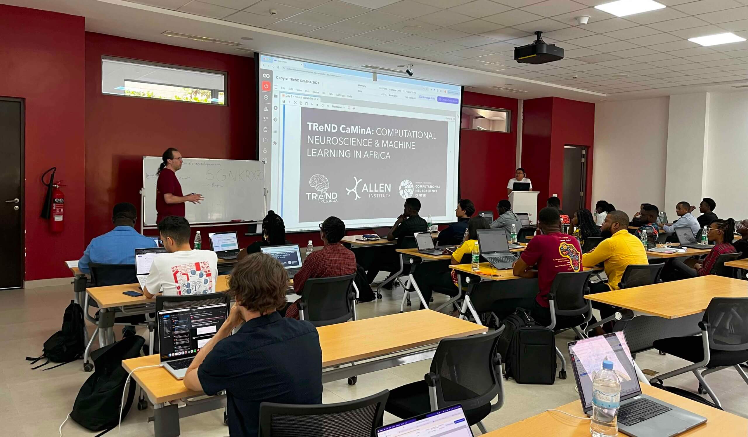 Academic conference lecture on computational neuroscience and machine learning in Africa with audience seated at tables