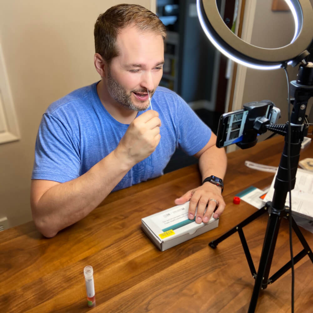 Rob Piercy, Director of Media Relations at the Allen Institute completes a SCAN test kit for SARS-CoV-2 during the podcast interview with Dr. Jay Shendure.