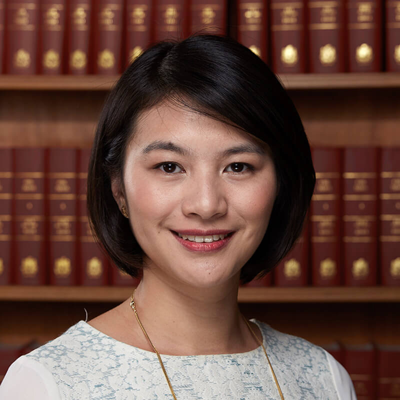 Woman smiling at camera in front of law library bookshelf
