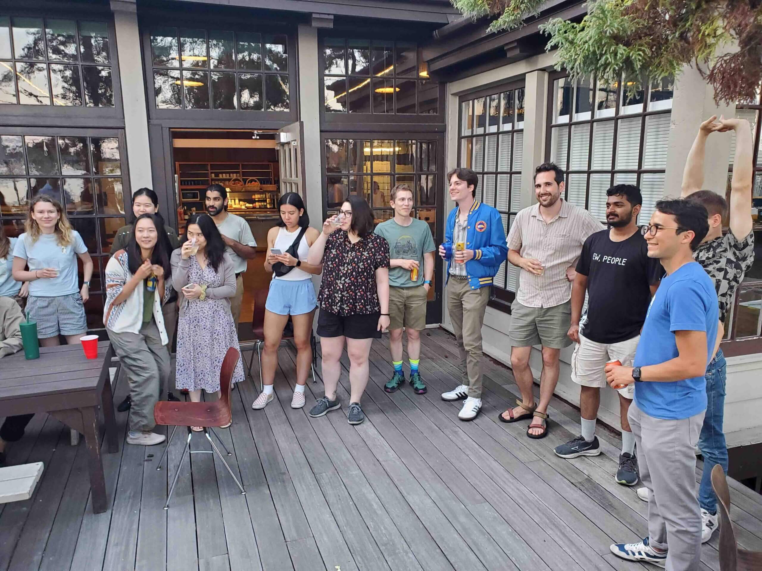 Group of diverse people socializing on an outdoor restaurant patio with drinks