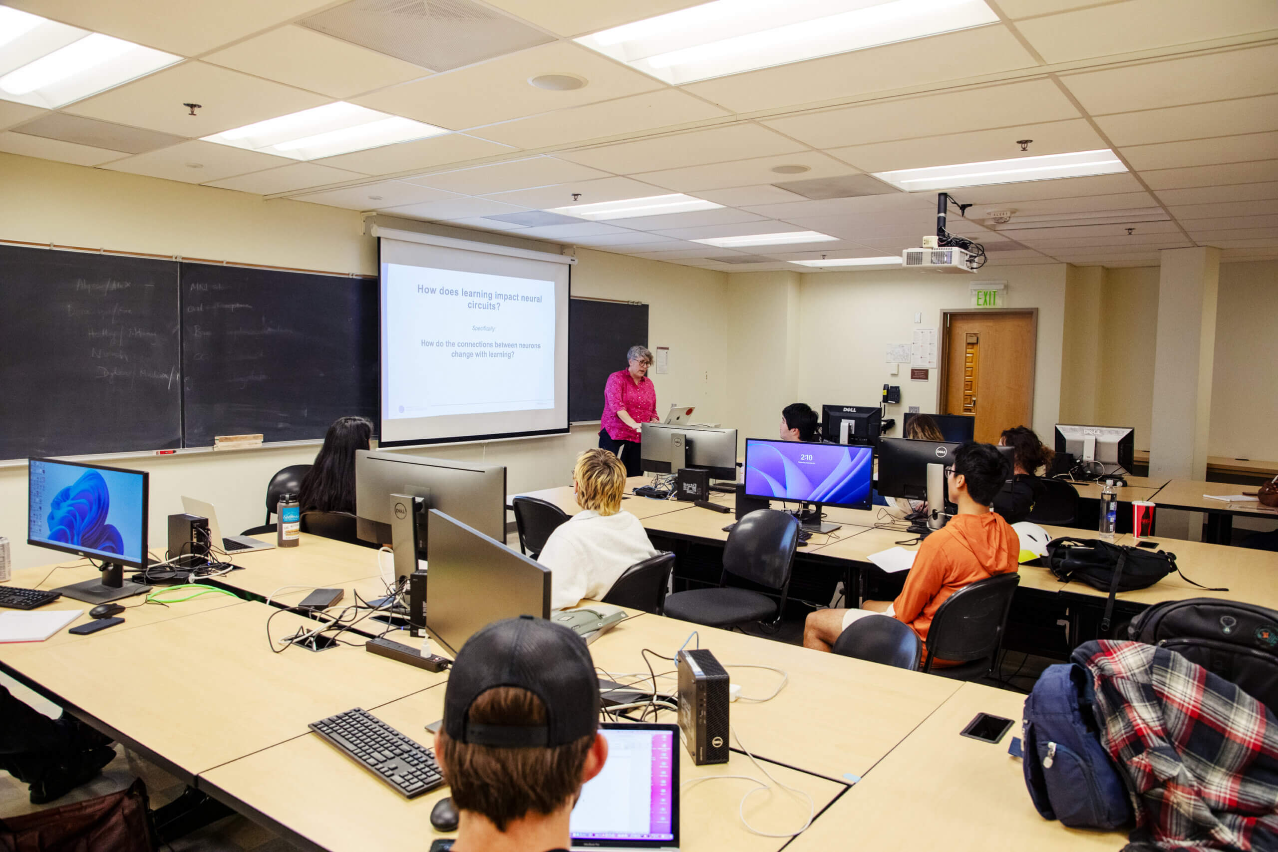 Instructor teaching neuroscience class to students at computers in classroom