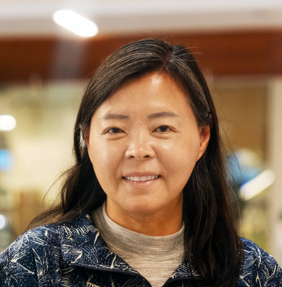 Portrait of smiling middle-aged Asian woman with long dark hair indoors