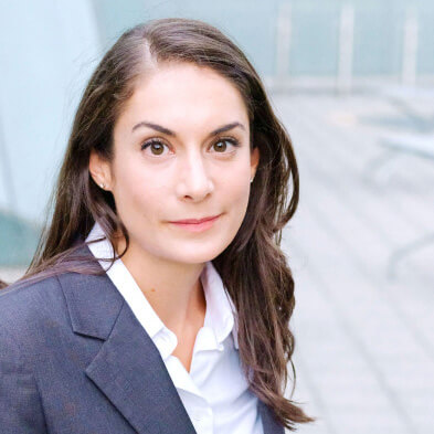 Professional businesswoman with long dark hair wearing navy blazer and white shirt