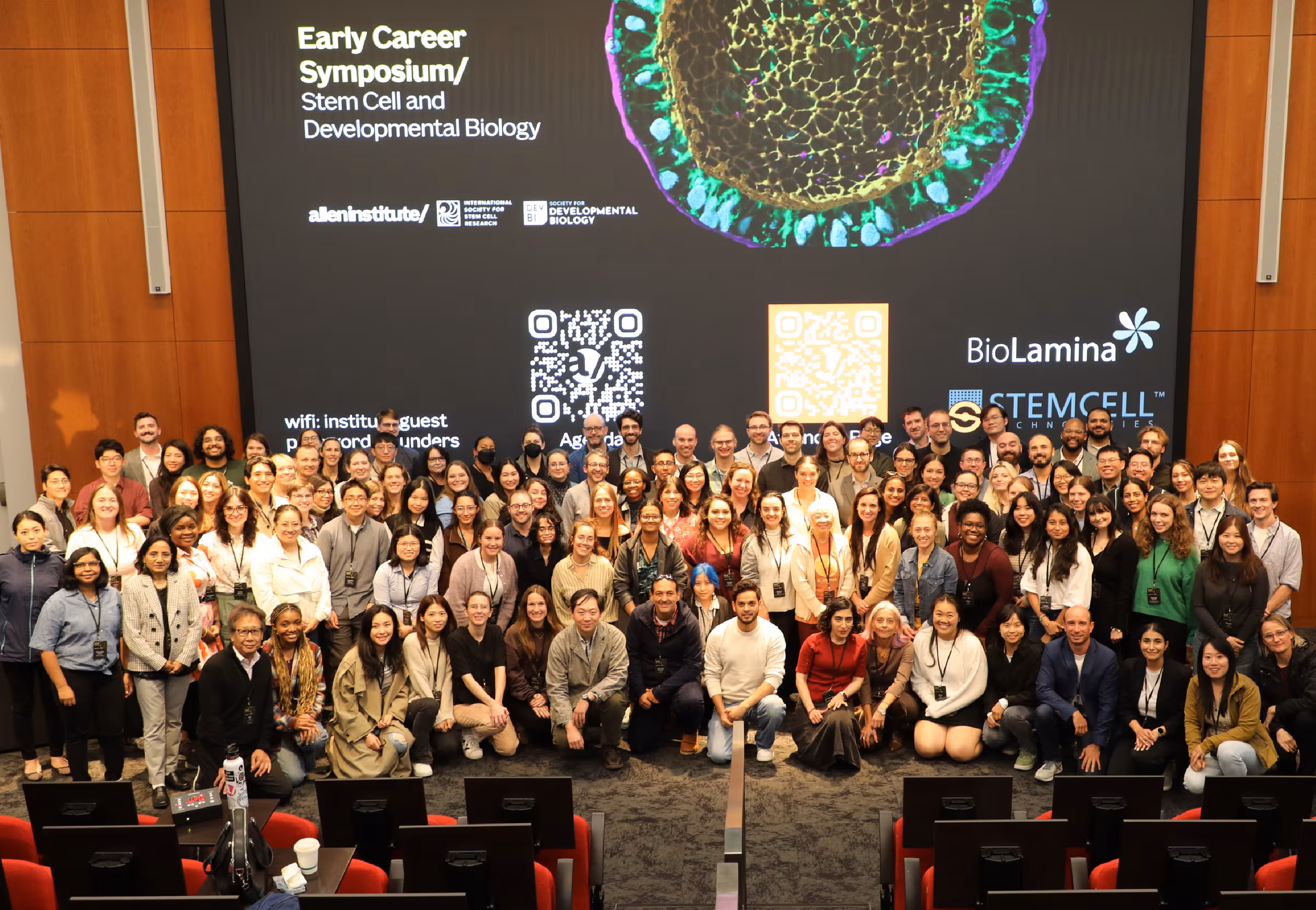 group of researchers in auditorium posing for photo