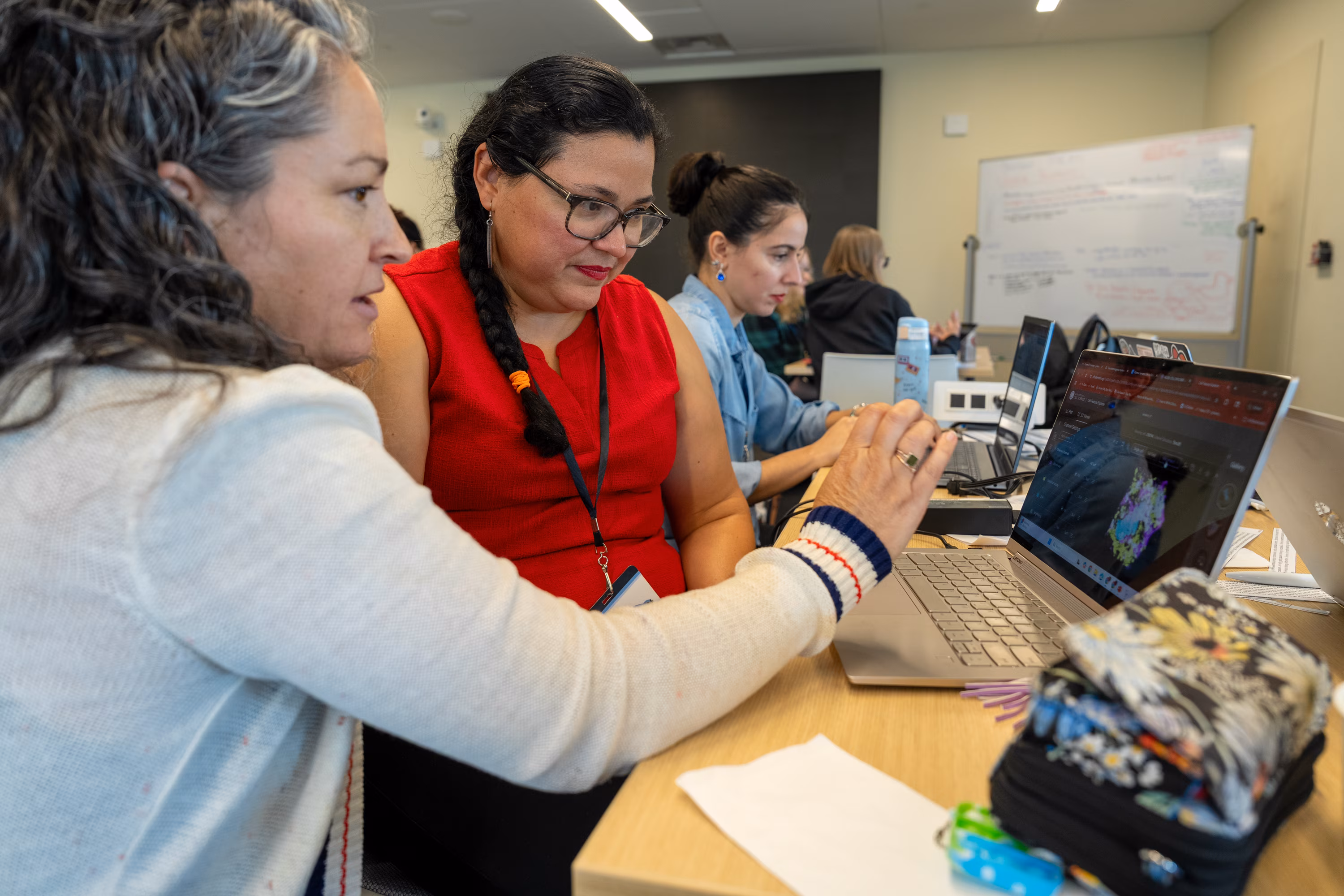 Women collaborating at computers during a professional workshop or training session