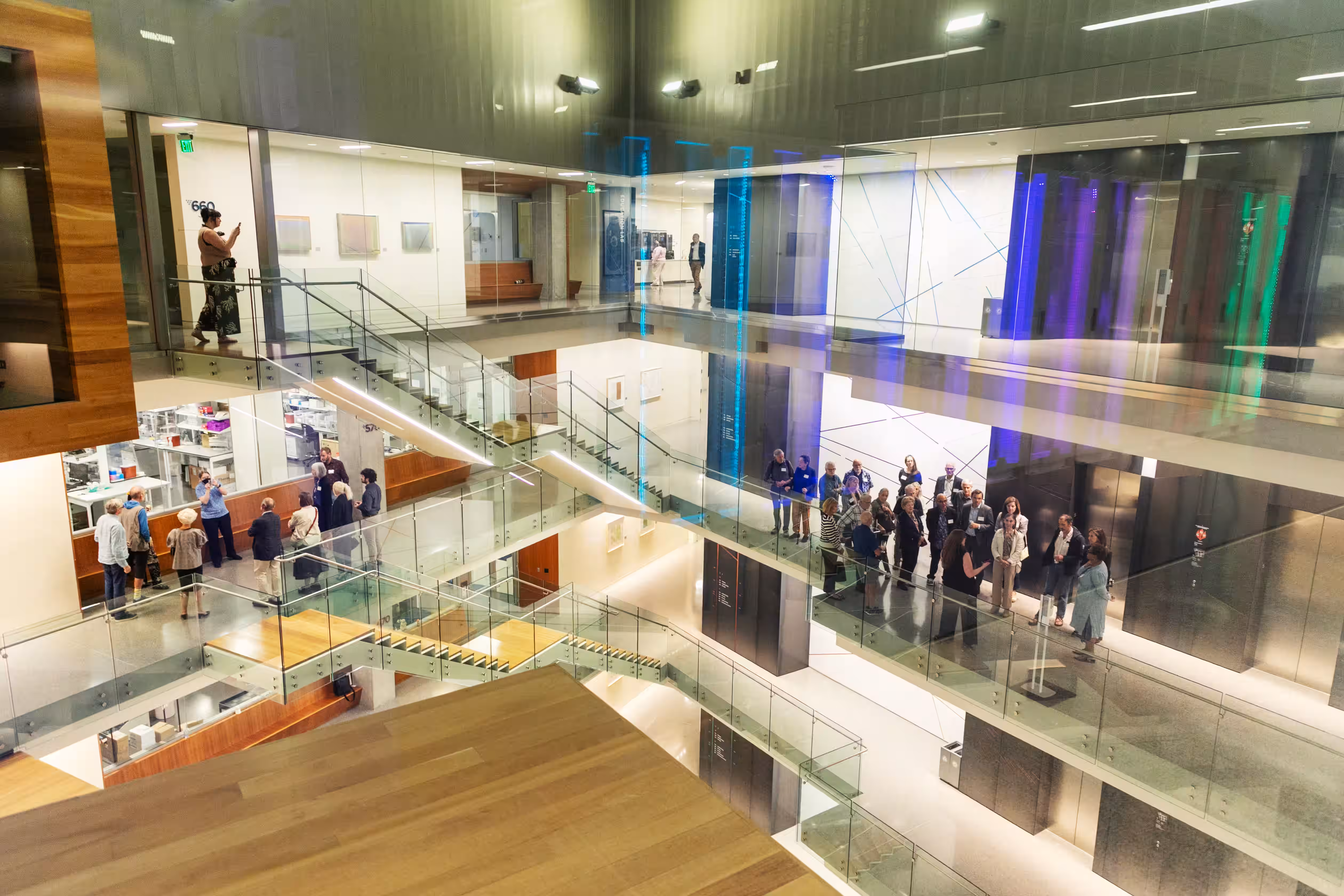 Allen Institute interior with multiple levels, glass railings, people on different floors, and blue lighting