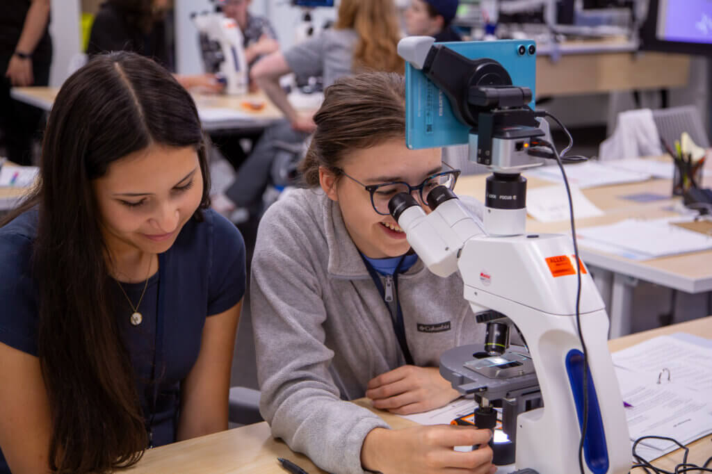 Students use microscope during hands-on science classroom activity and learning session
