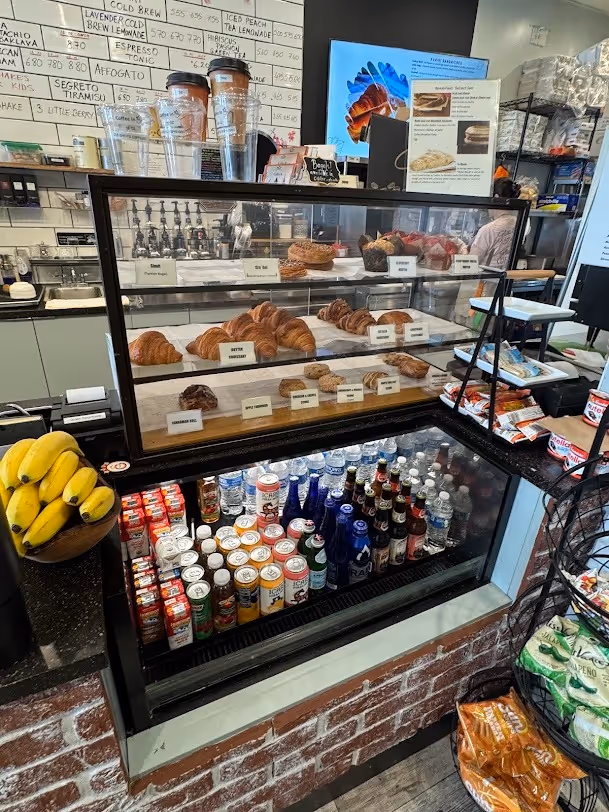 A bakery counter featuring a display case filled with various baked goods and pastries