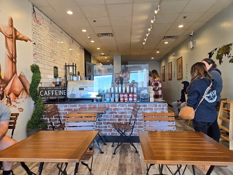 People are seated at tables in a cozy coffee shop, engaged in conversation and enjoying their drinks.