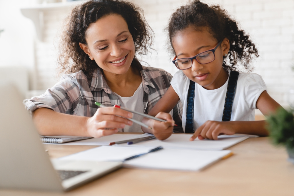 Mother and daughter practicing reading and listening activities at home for improved comprehension