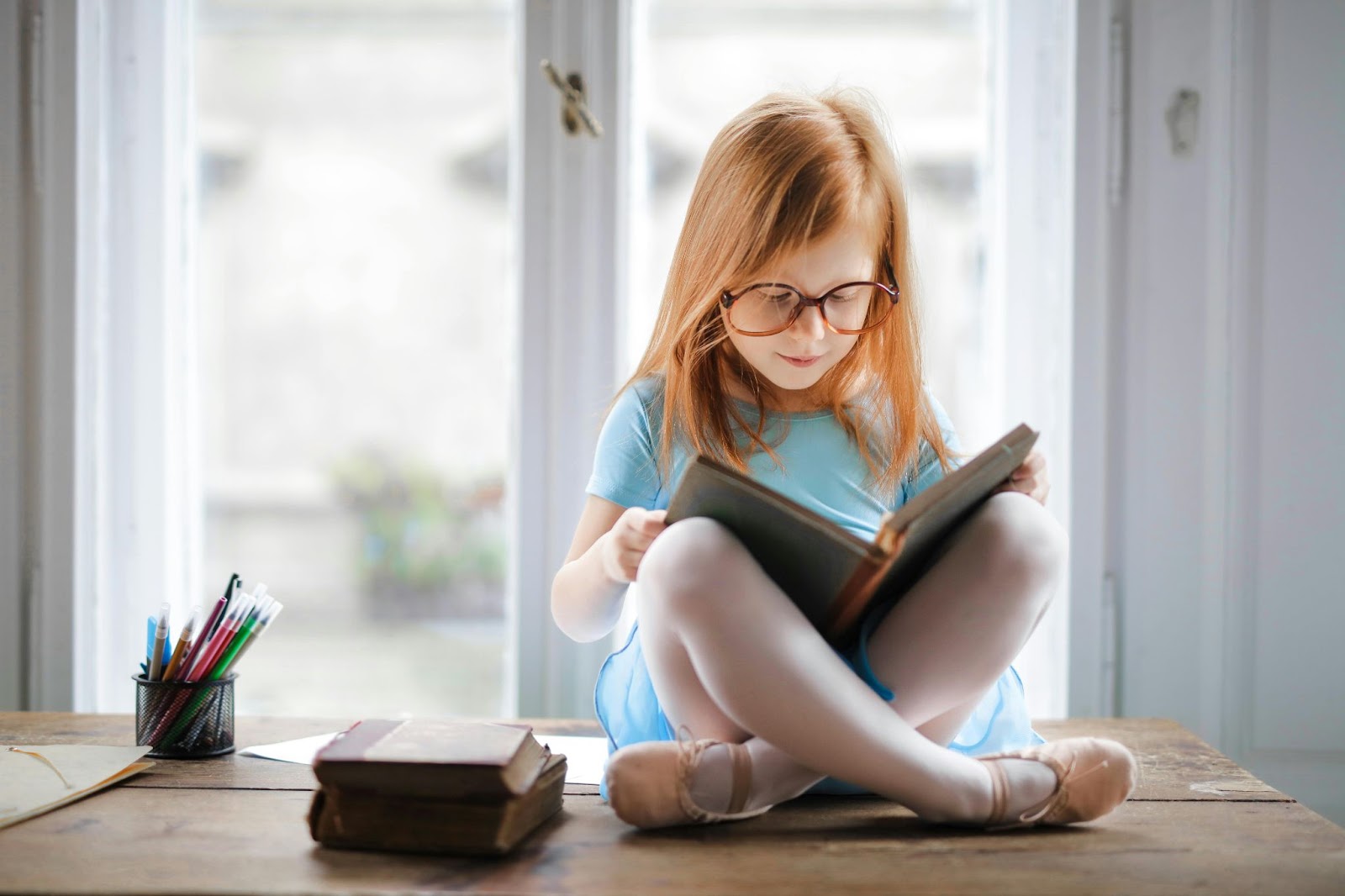 Young girl demonstrating reading success at home with a book