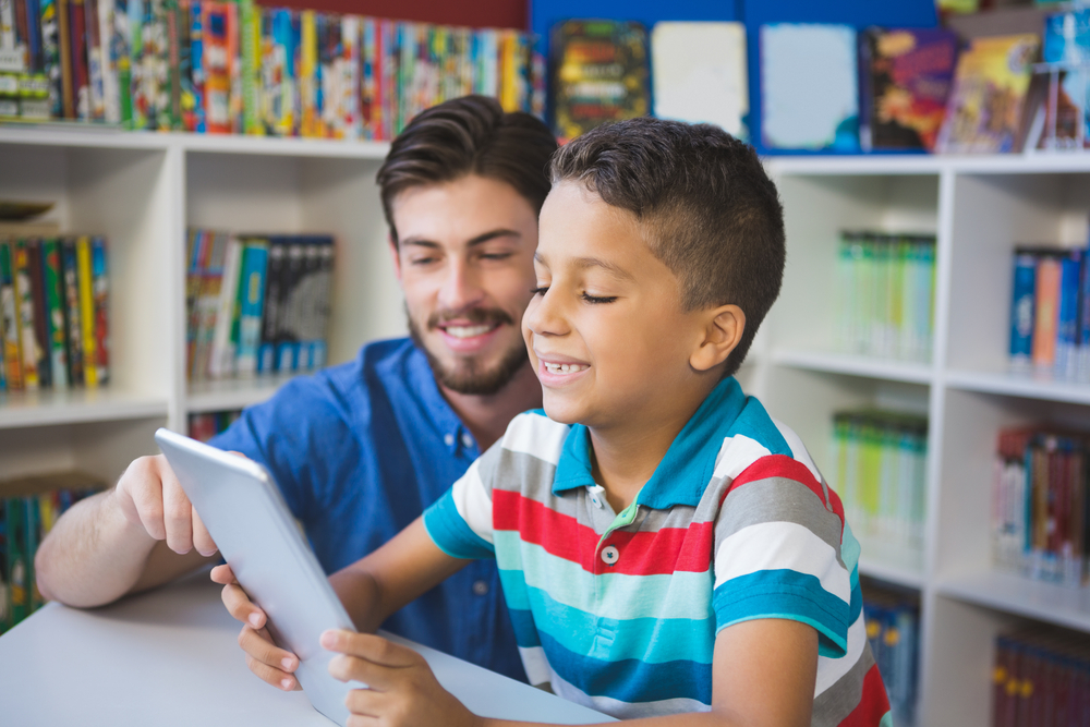 Boy reading with mentor addressing illiteracy in California