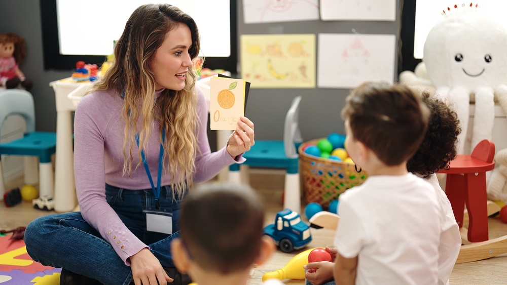 Teacher helping children with reading and comprehension
