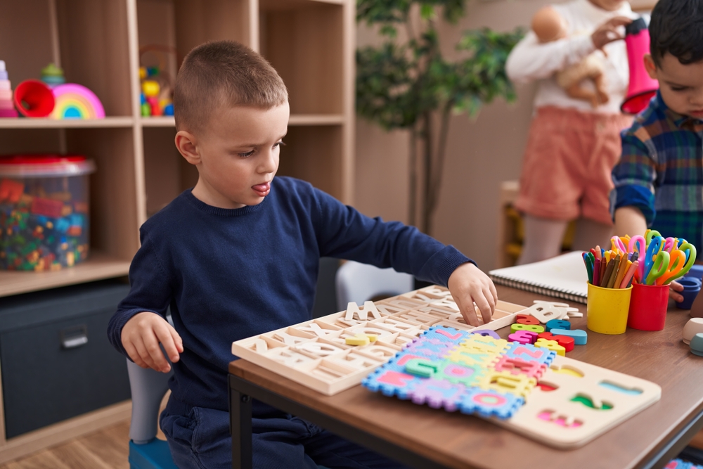 Boy in a classroom using educational materials, focusing on reading progress