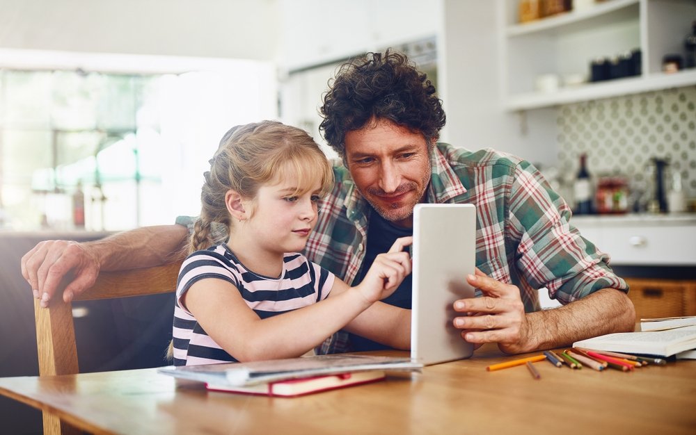 Parent assisting child with reading comprehension on a tablet