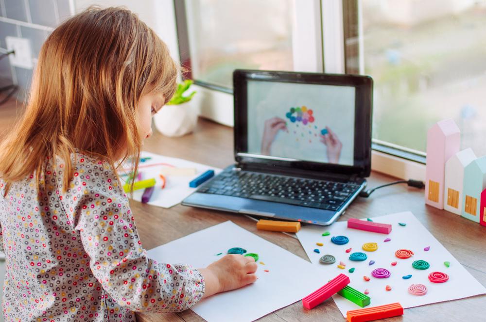 Child engaging in creative activities alongside an educational video, highlighting the benefits of reading rewards programs
