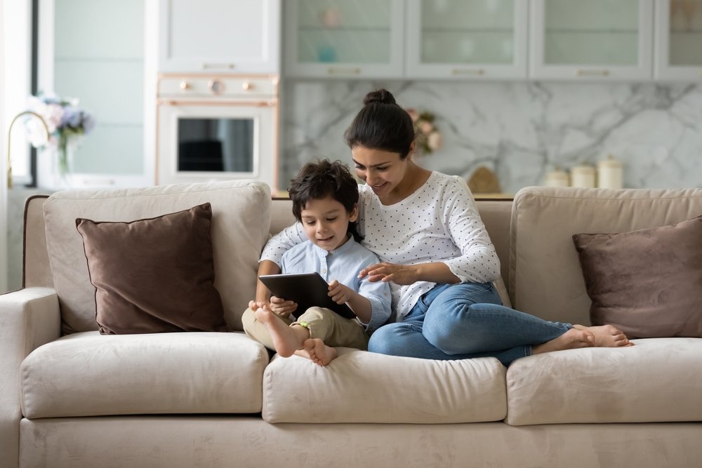 Parent and child reading on a couch, focusing on progressive reading skills