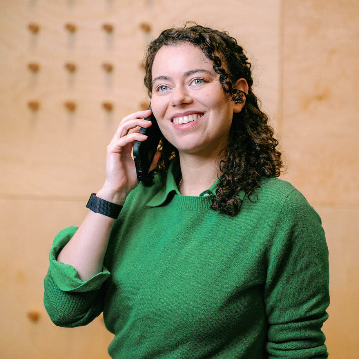Emma Anderson Beavers in a green sweater talking on a smartphone