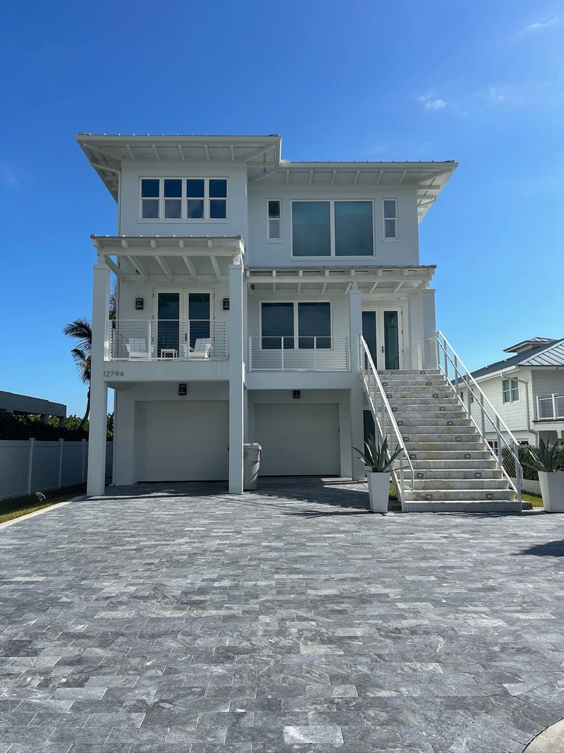 Aerial view of large stone home with new asphalt shingles surrounded by trees in Southlake TX