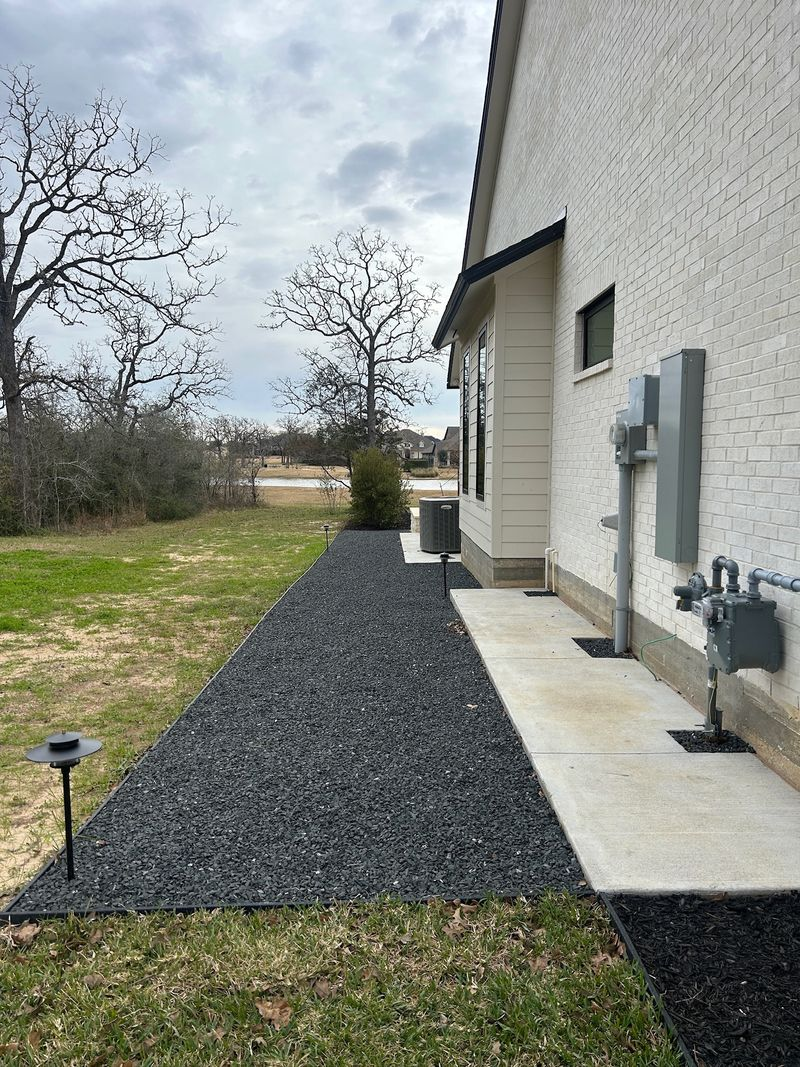 Side view of large stone home with multiple roof pitches and new shingles in Southlake TX