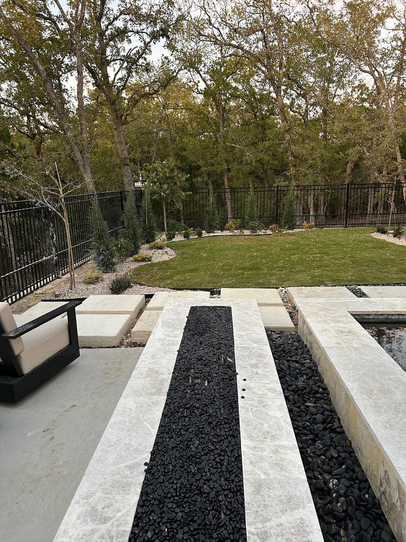 Side view of large stone home with multiple roof pitches and new shingles in Southlake TX