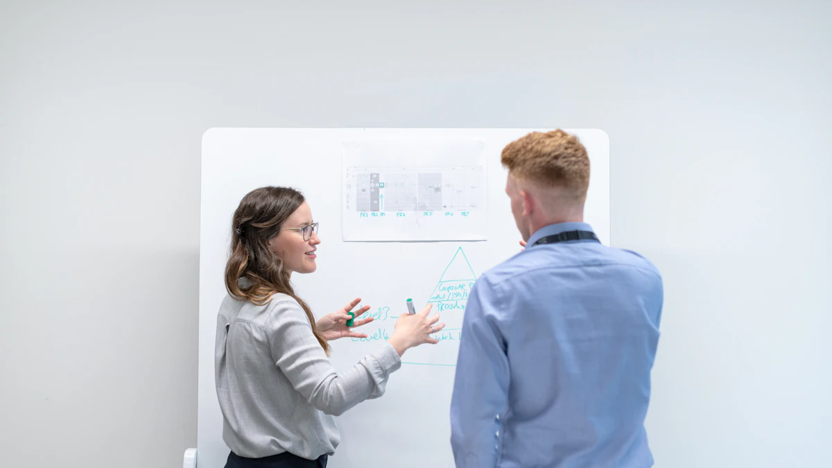 Two engineers discussing a technical diagram at a whiteboard.