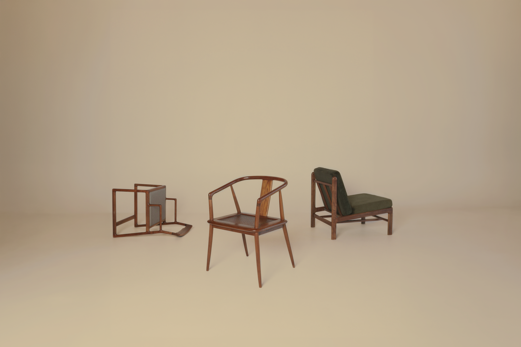 Three wooden chairs on beige background; one upright, one tipped over, one with dark cushions.