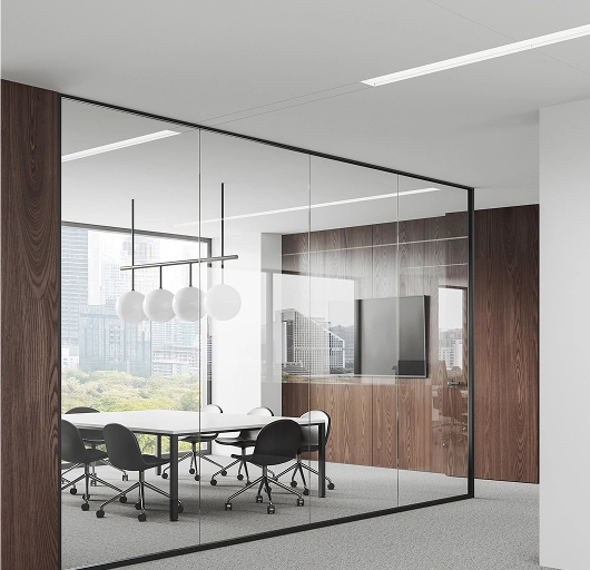 Modern glass-walled conference room with a white table, black office chairs, spherical pendant lights, and a cityscape view through large windows.