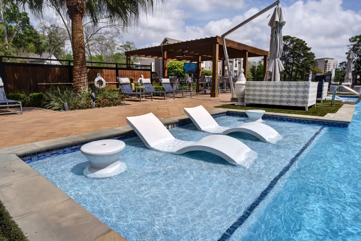 Swimming pool with lounge chairs and table in pool