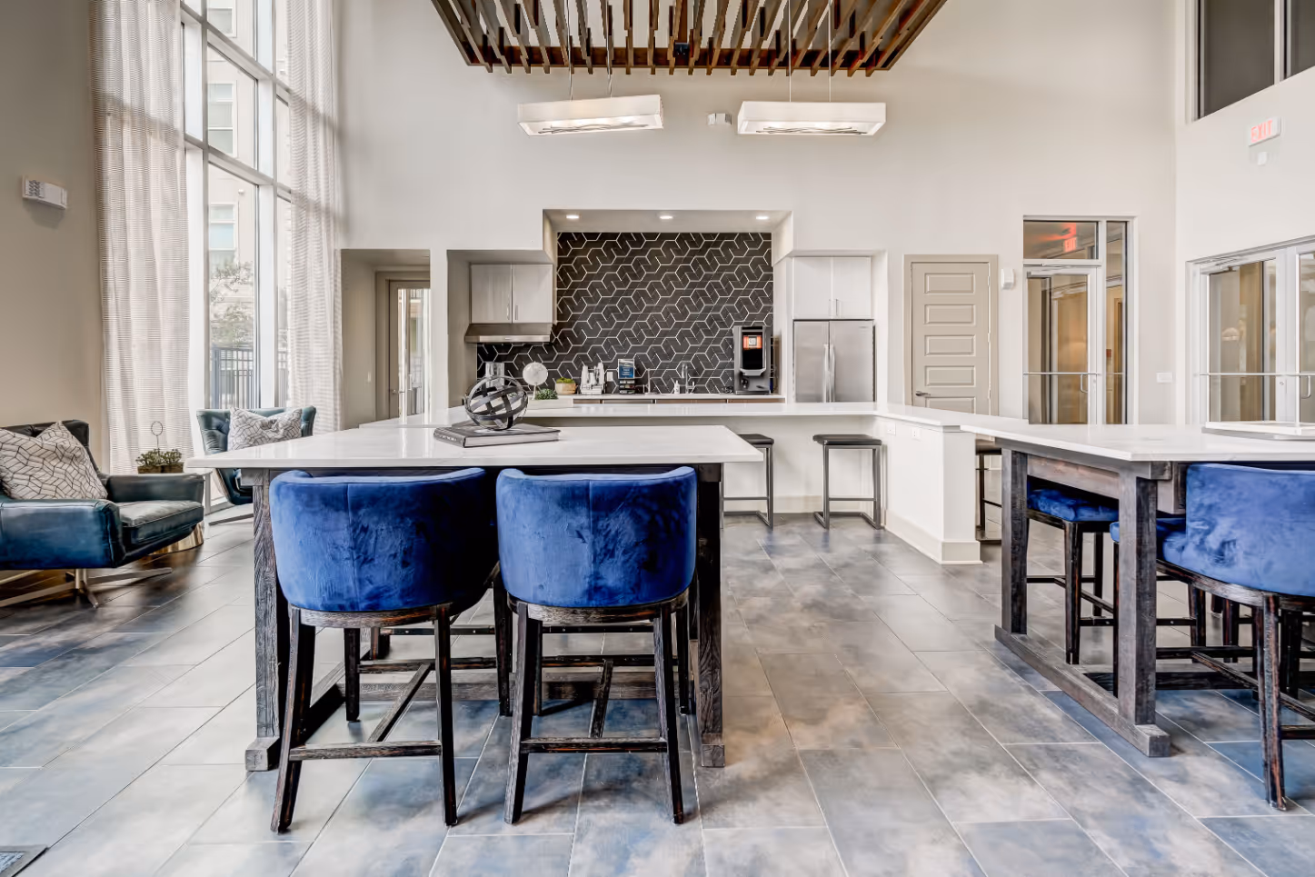 Community lounge and kitchen having stainless steel appliances, sofa, tables and chairs