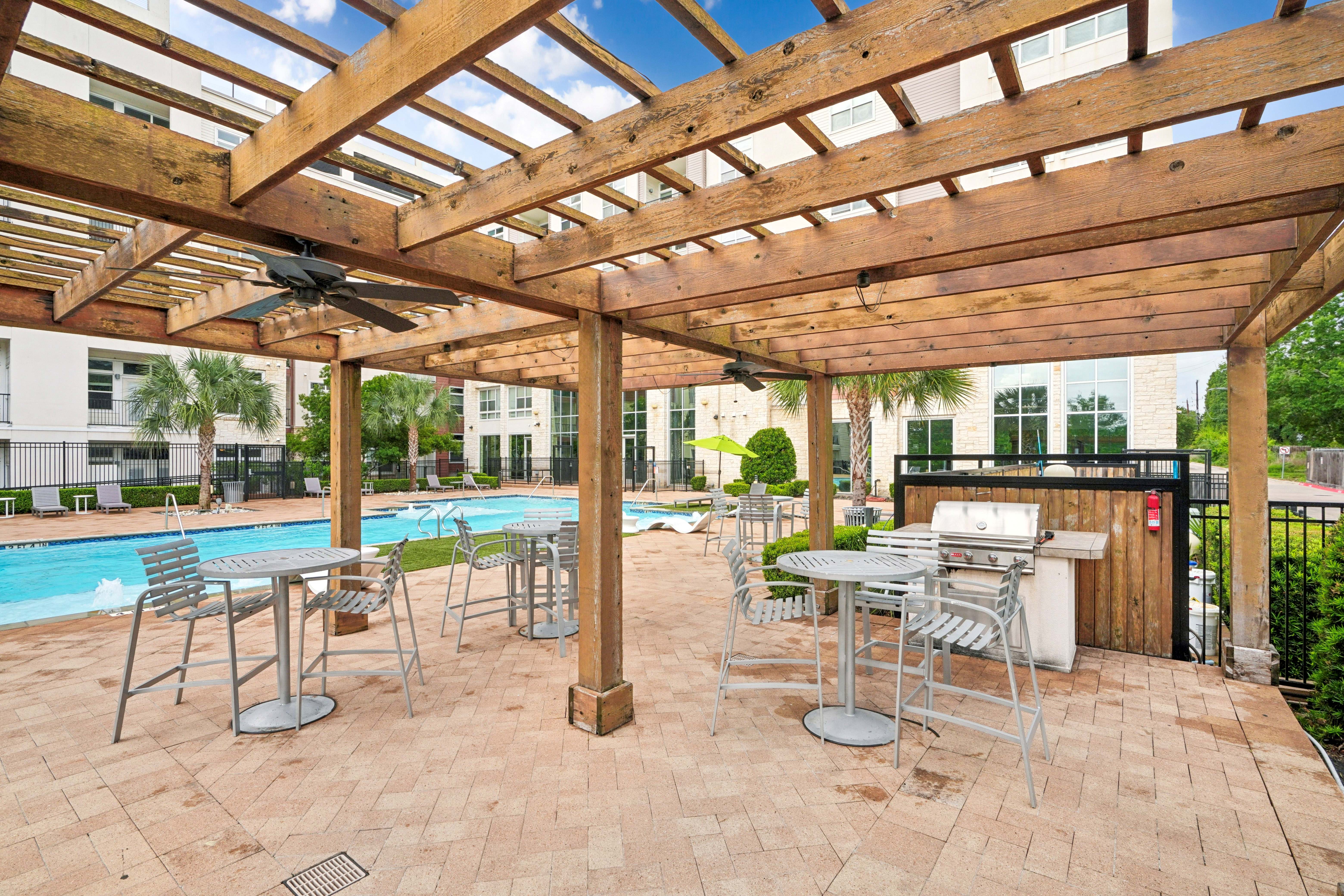 Chairs and fire pit near cabana near pool