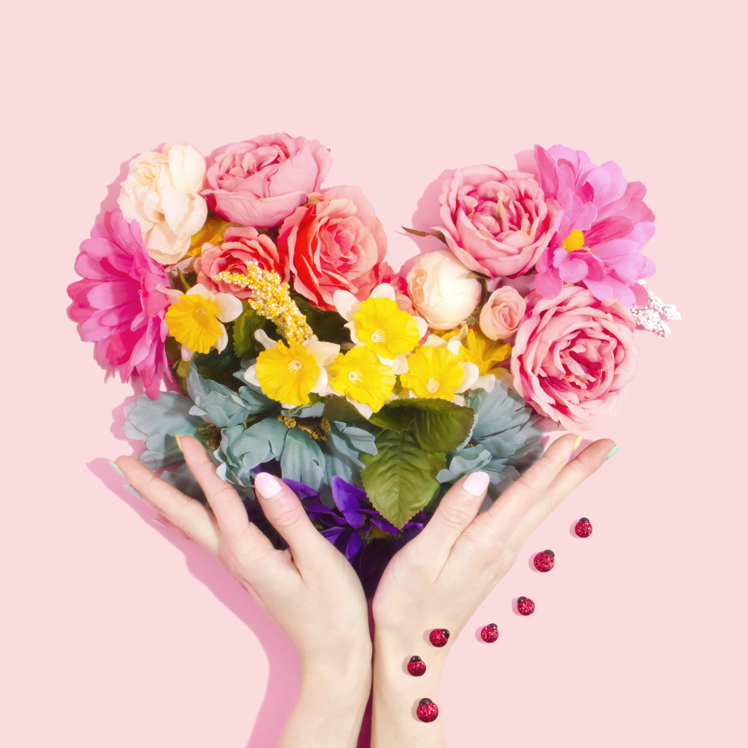 A person holding a small bouquet of soft pink and white flowers, a quiet gesture of gratitude for Mother's Day