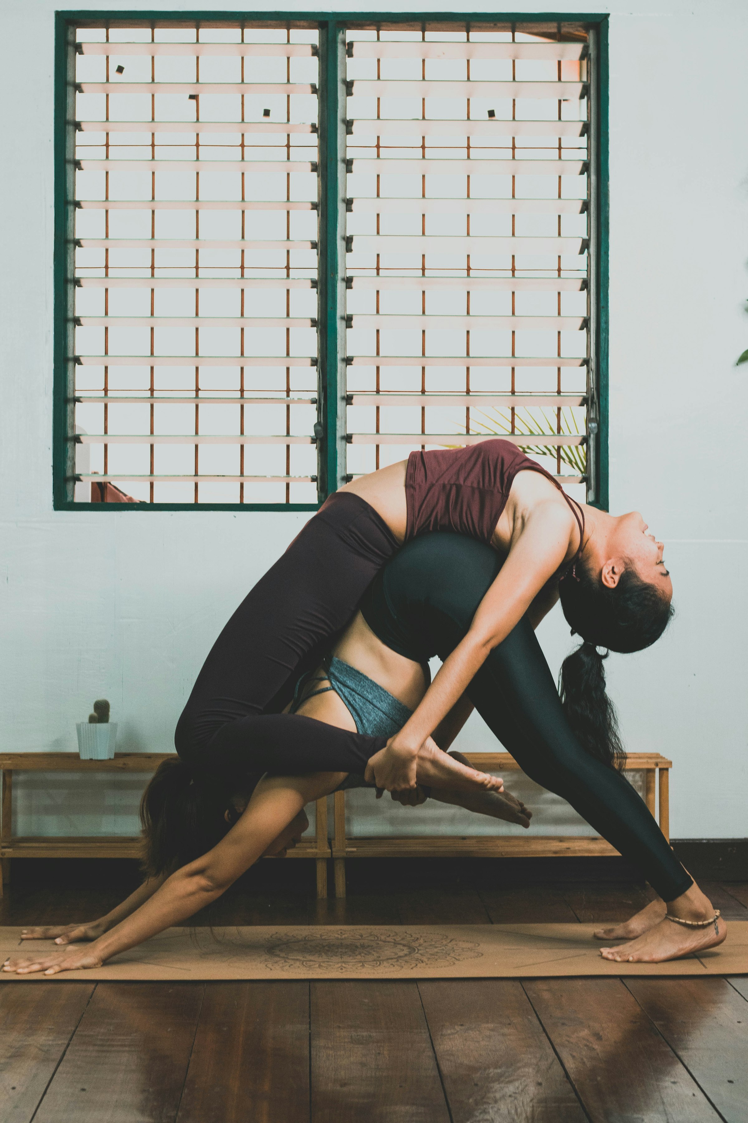 Person in a blue top holding a deep, flexible yoga stretch, illustrating Atlassian's new Flex model that lets enterprises bend and adapt their software adoption. Photo by Carl Barcelo on Unsplash.