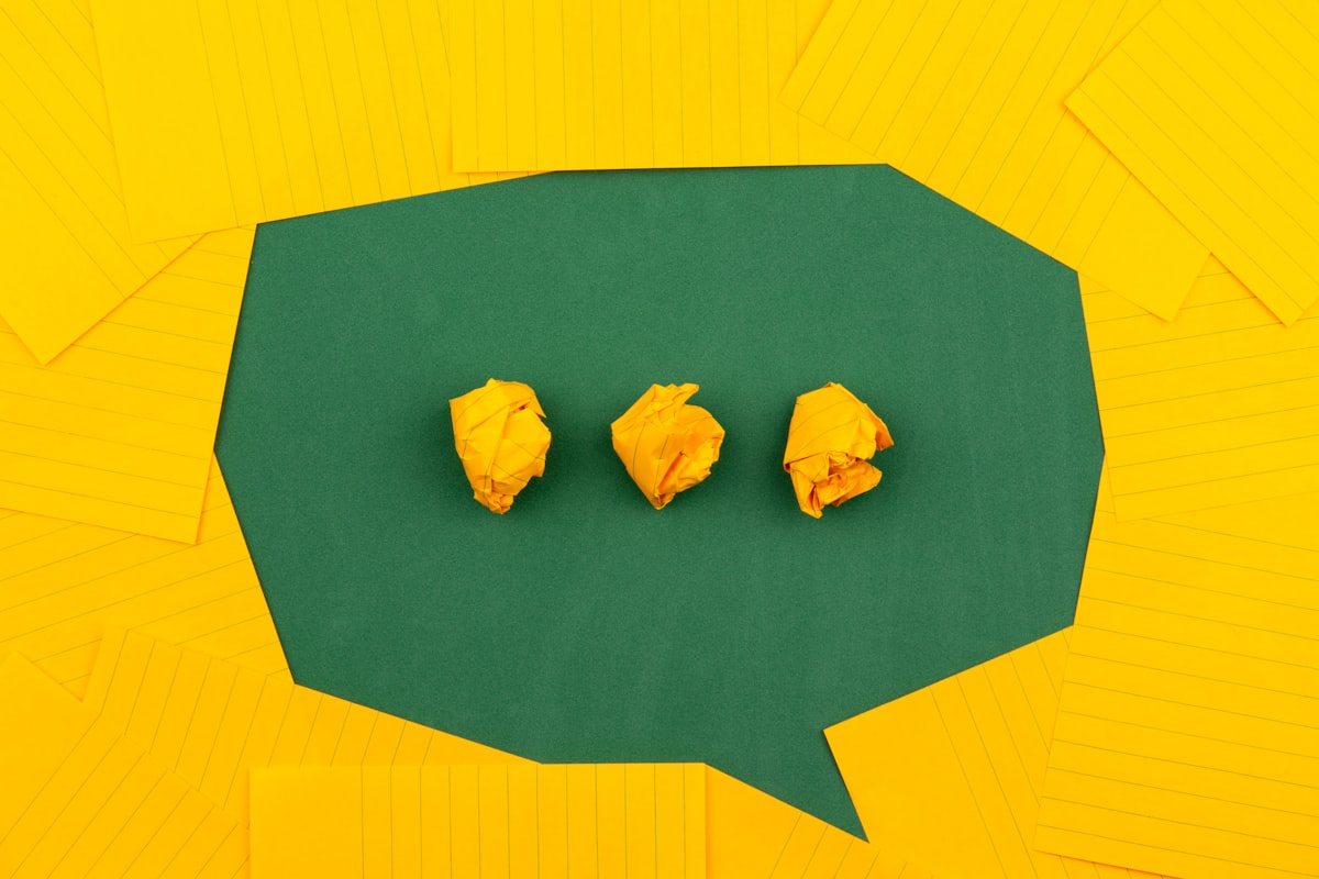 A single paper speech bubble pinned against a bright blue background, representing asking your organization a question and getting a sourced answer. Photo from Unsplash.