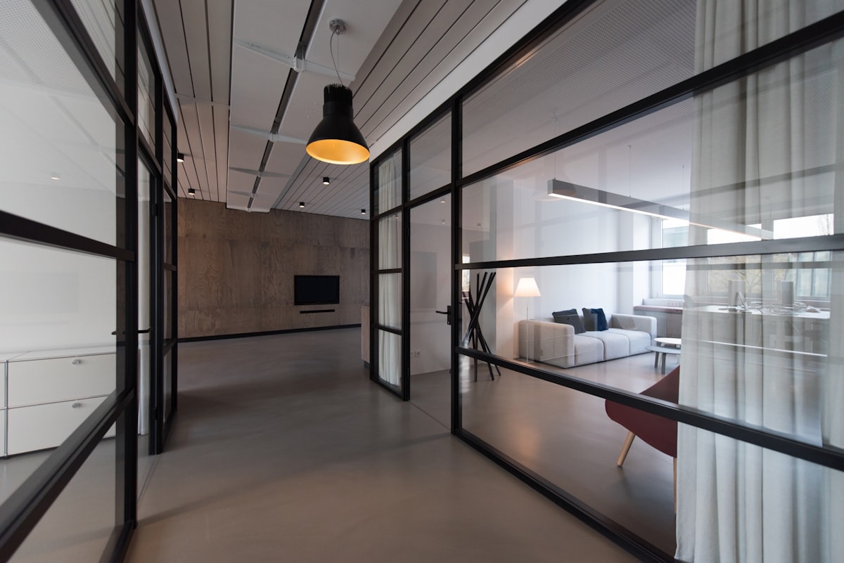 A clean, modern professional office with a glass divider, illustrating standing up Jira Service Management as a legal team's organized intake front door. Photo from Unsplash.