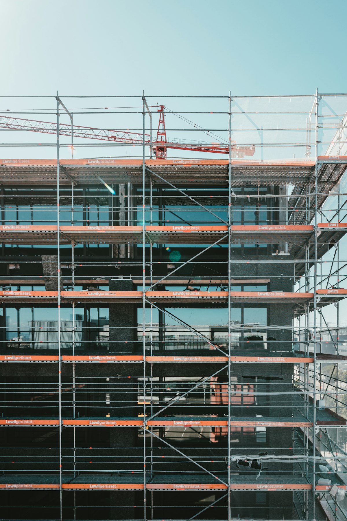 A grid of metal scaffolding against a building facade, illustrating that the Atlassian for Startups free year is temporary support around whatever a founding team actually builds underneath it. Photo by Claudio Schwarz on Unsplash.