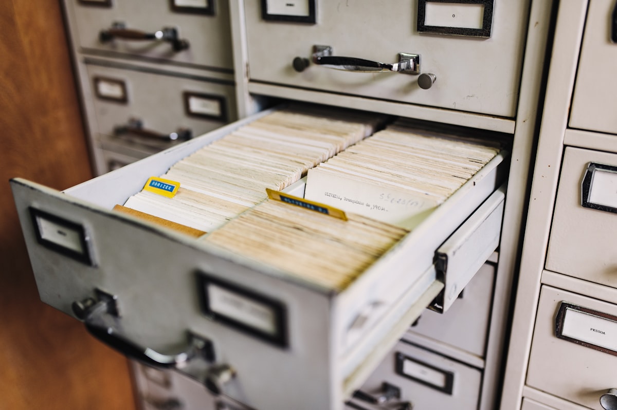 An open filing cabinet drawer packed with index cards, illustrating the scattered document knowledge that Atlassian's Google Drive and SharePoint connectors bring into the Teamwork Graph. Photo from Unsplash.