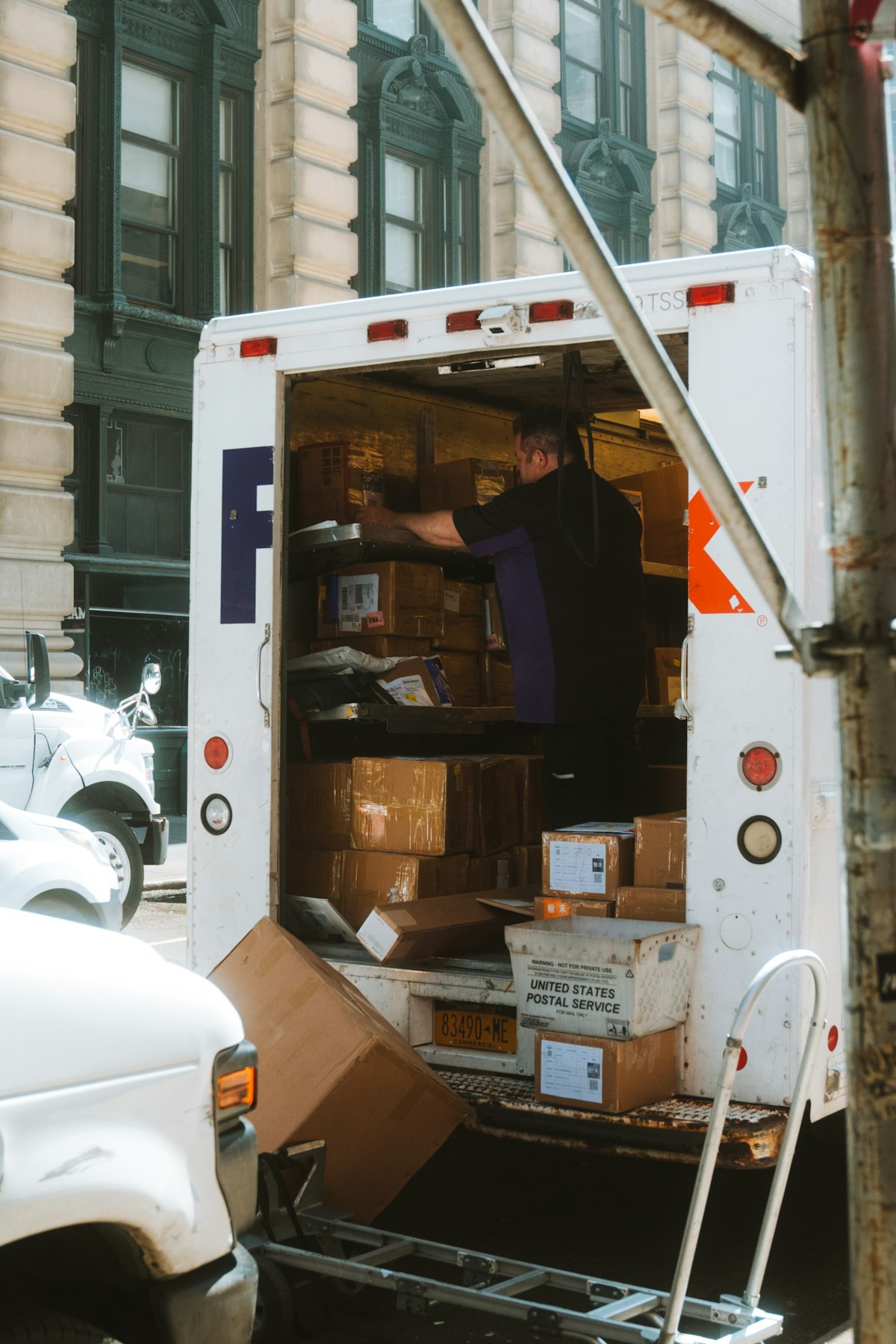 A person loading cardboard moving boxes into a moving truck, illustrating Atlassian Assets moving out of Jira Service Management to become a standalone platform app. Photo from Unsplash.