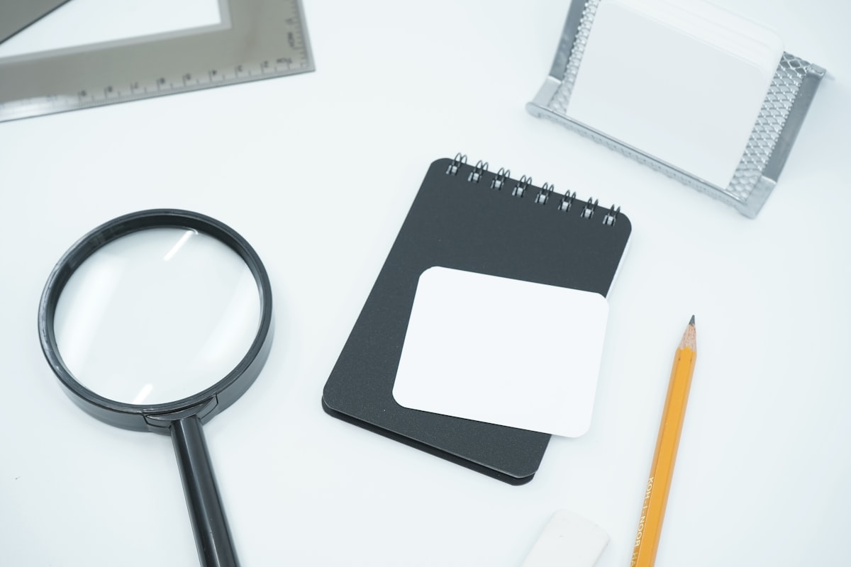 A black magnifying glass resting on a printed document, illustrating the hunt for the source of a Jira Service Management statistic. Photo from Unsplash.