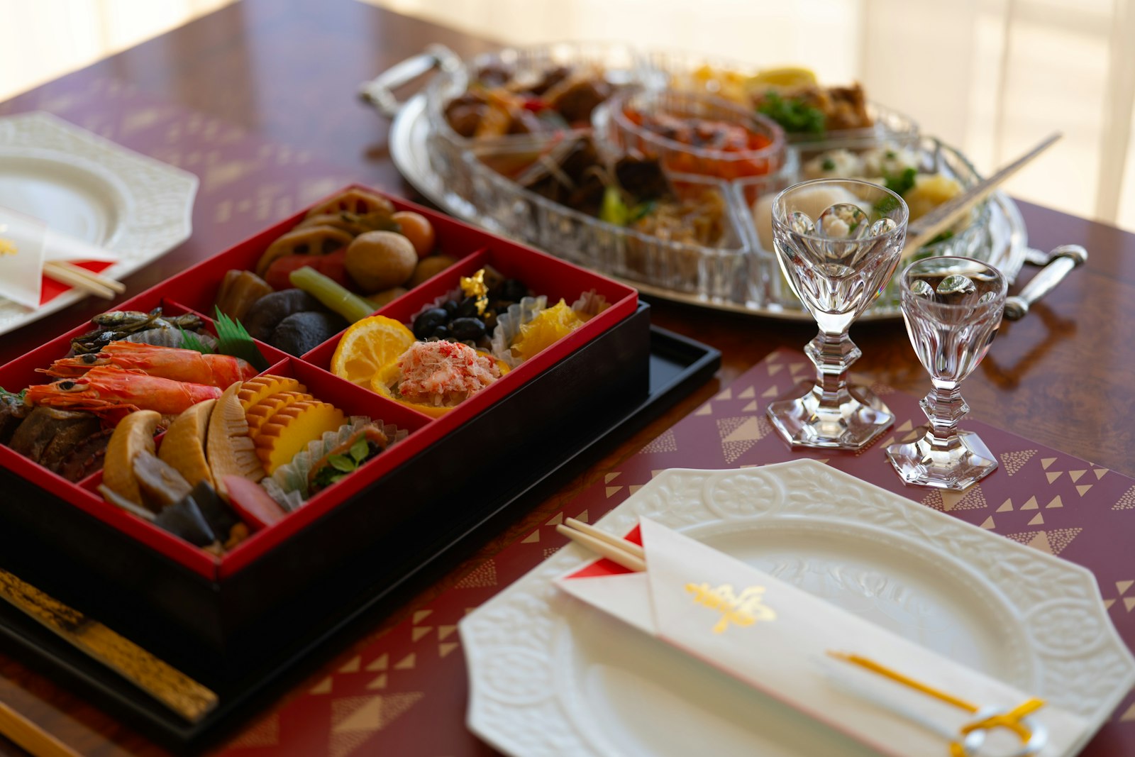 Traditional Japanese osechi box photographed from above, its lacquered compartments filled with an assortment of curated dishes