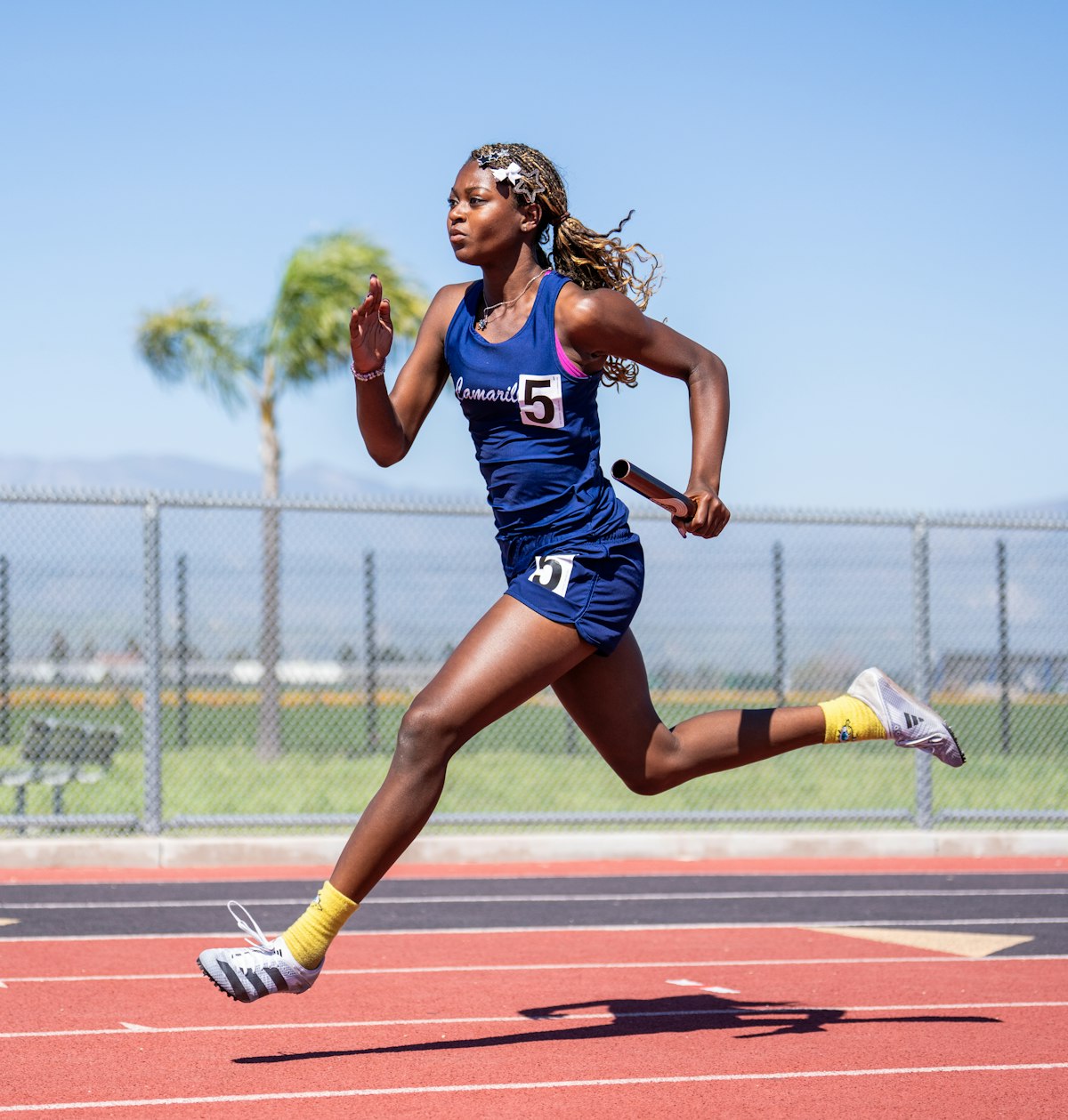 A runner sprints down a track holding a relay baton, a visual stand-in for context carried from one teammate to the next in Rovo Chat.