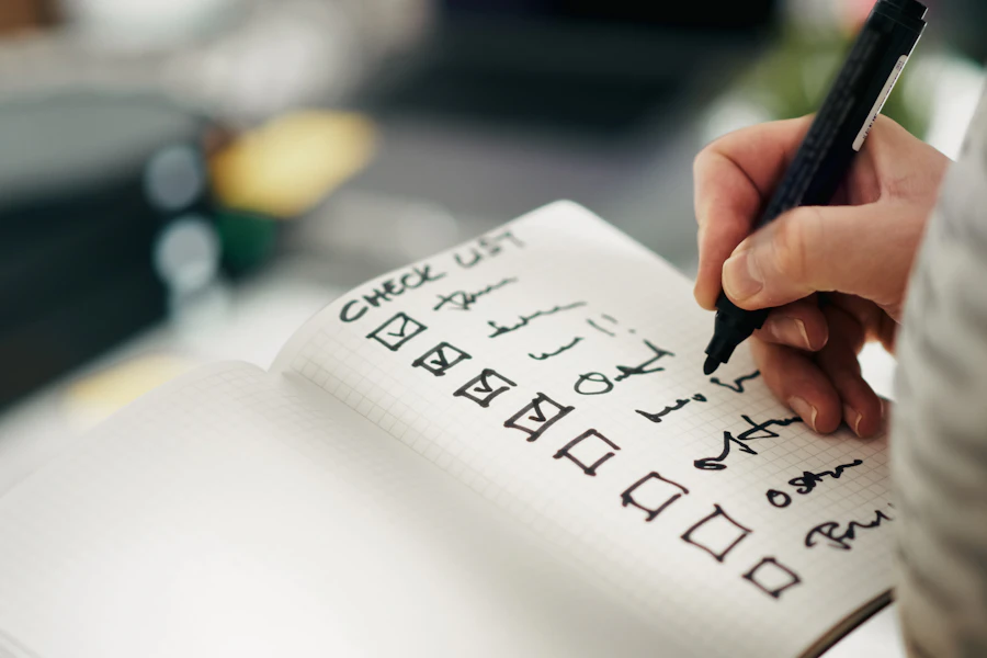 A hand checking completed items in a notebook