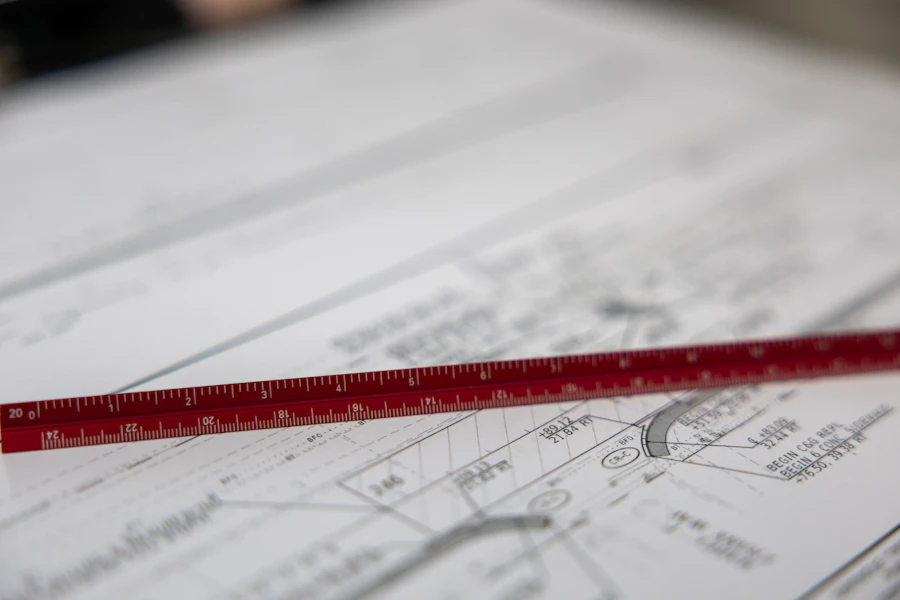 A ruler laid across detailed technical drawings