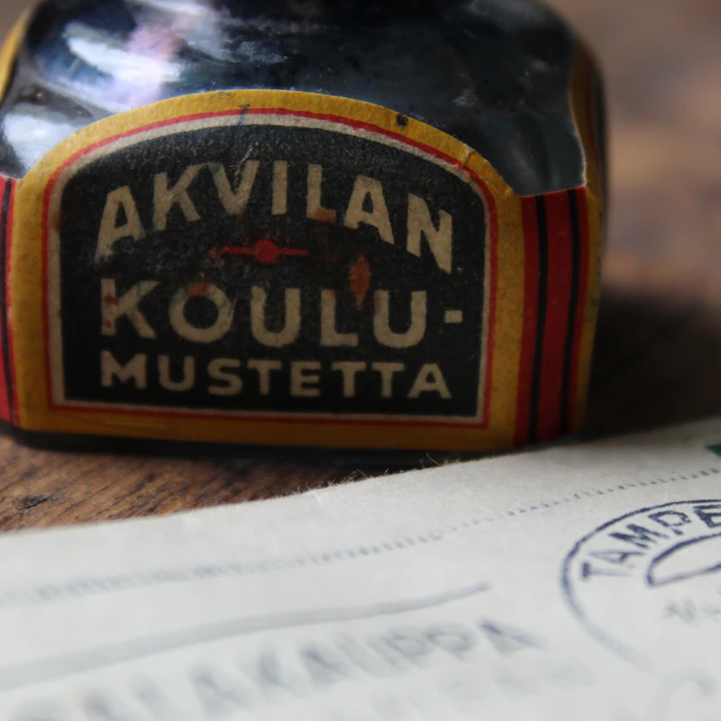 An ink bottle beside a handwritten letter