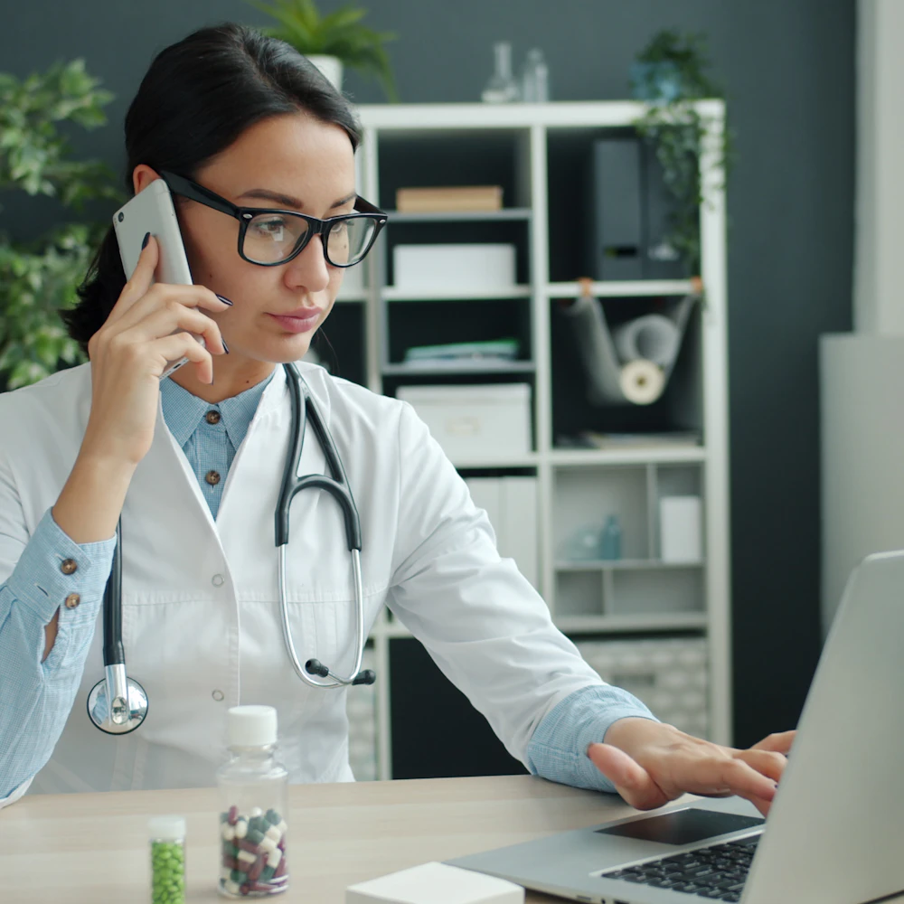 A clinician using a laptop to access healthcare knowledge and documentation.