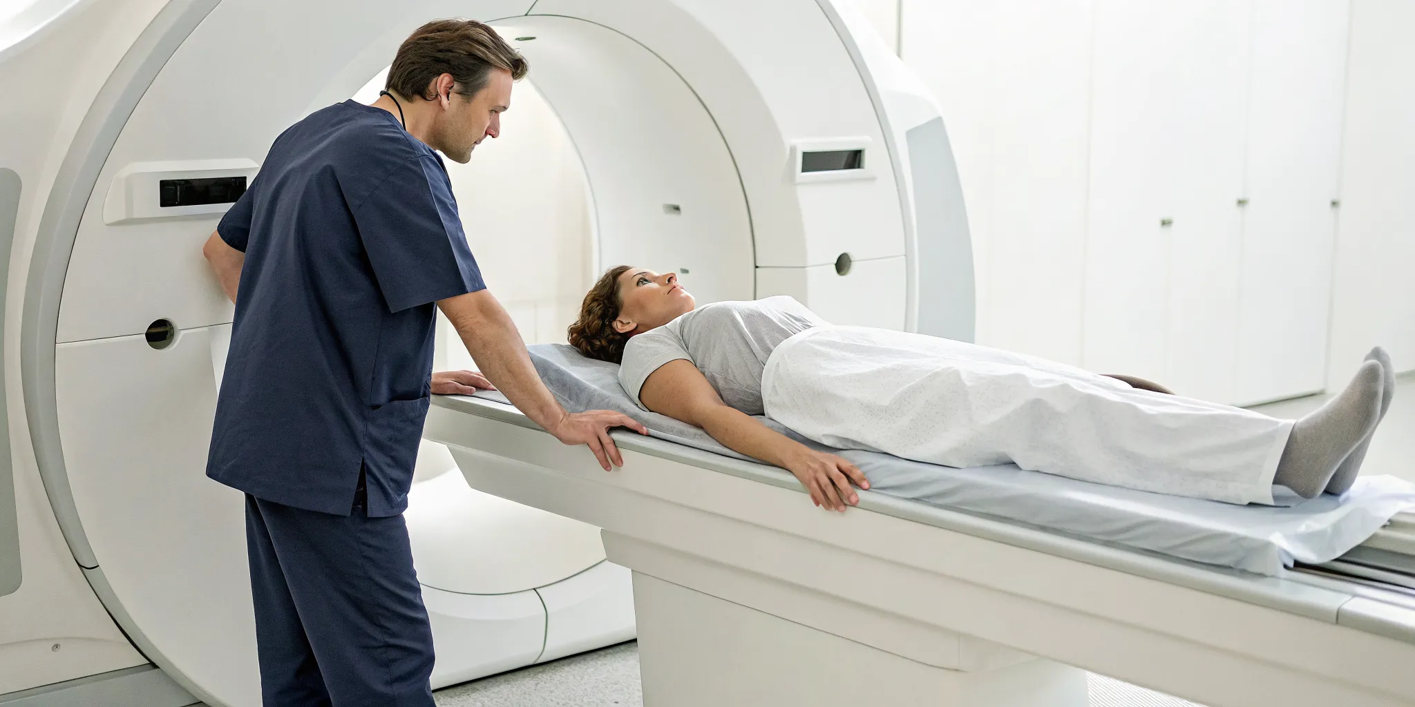 A technician prepares a patient on a table for their DEXA scan appointment.