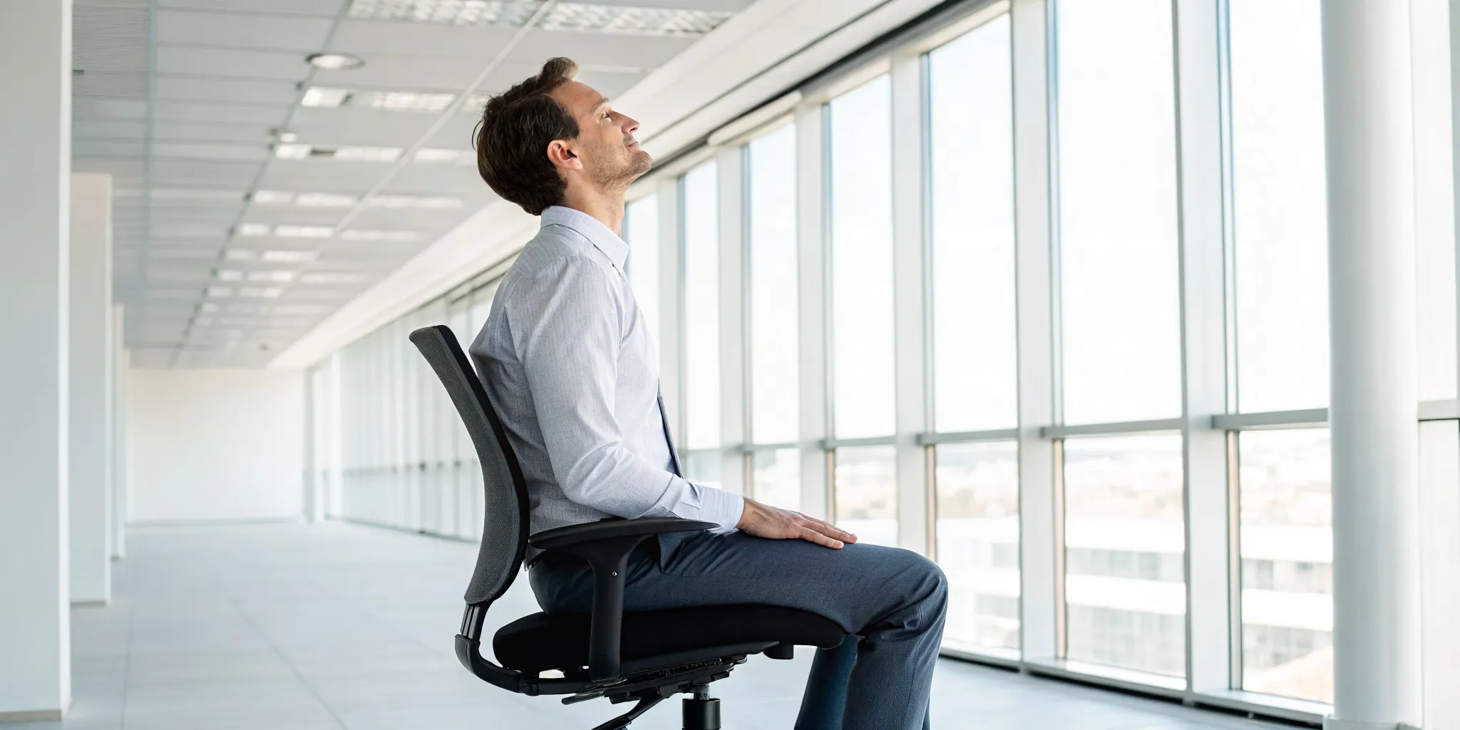 Man practicing good posture in an office chair to manage chronic back pain.