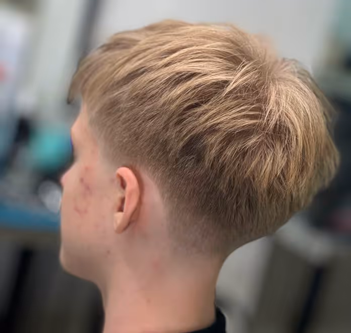 Junger Mann mit blondem Kurzhaarschnitt von hinten