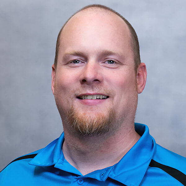 Smiling IT consultant in blue polo shirt, Systems Tech Consultant MSP team member, Billings MT managed services